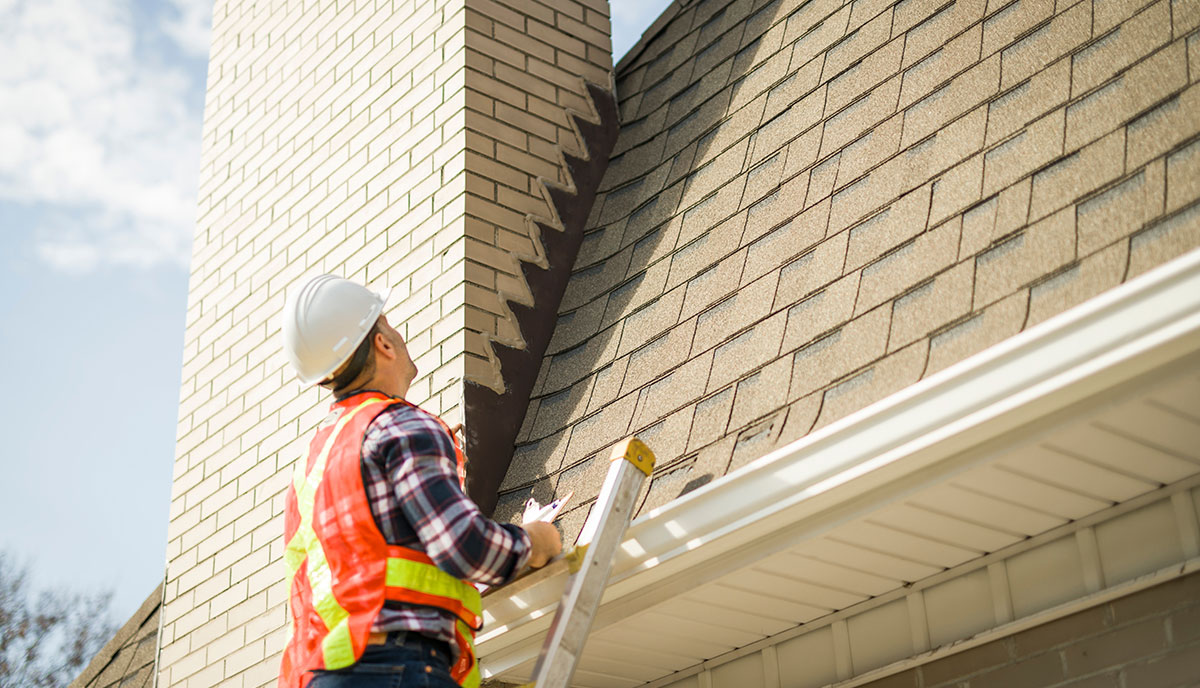 Expert Roofer Inspecting Commercial Roof Shingles