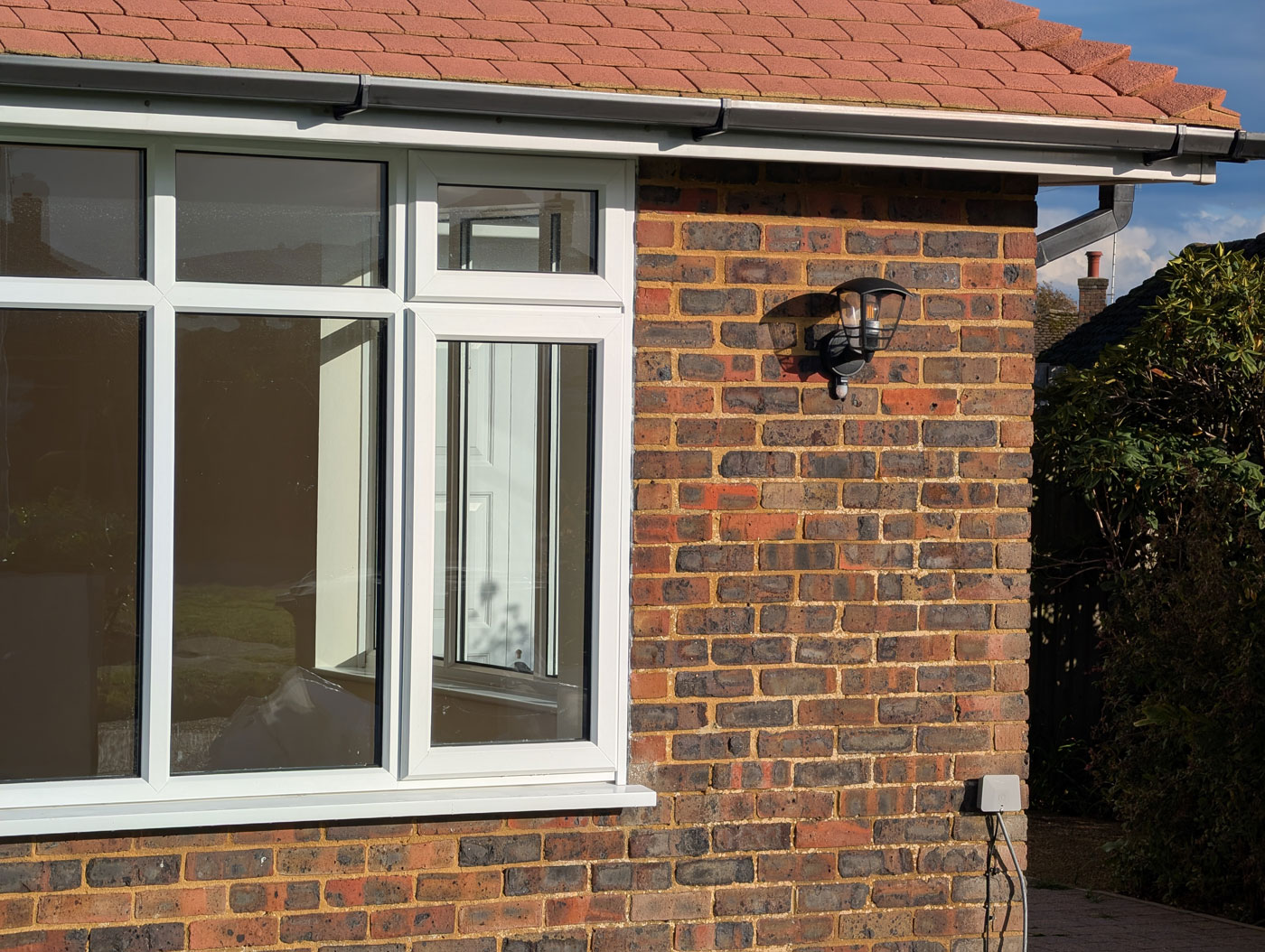 Raydiant Roofing Man Brick House with White Windows